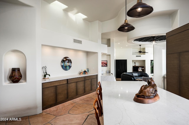 dining area with a high ceiling, ceiling fan, and a skylight