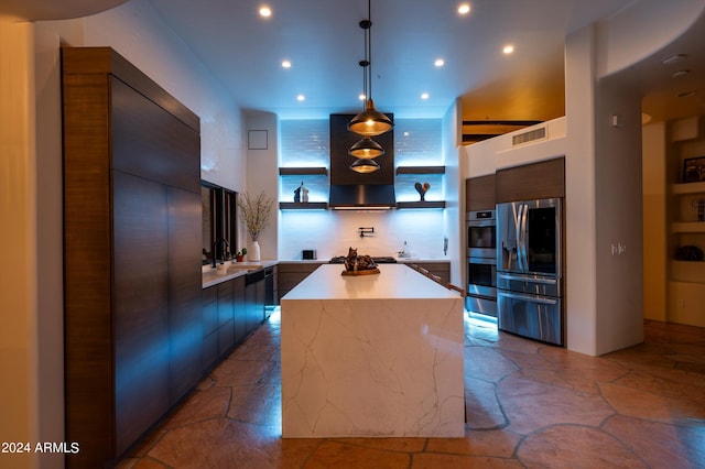 kitchen featuring extractor fan, sink, decorative light fixtures, a center island, and appliances with stainless steel finishes