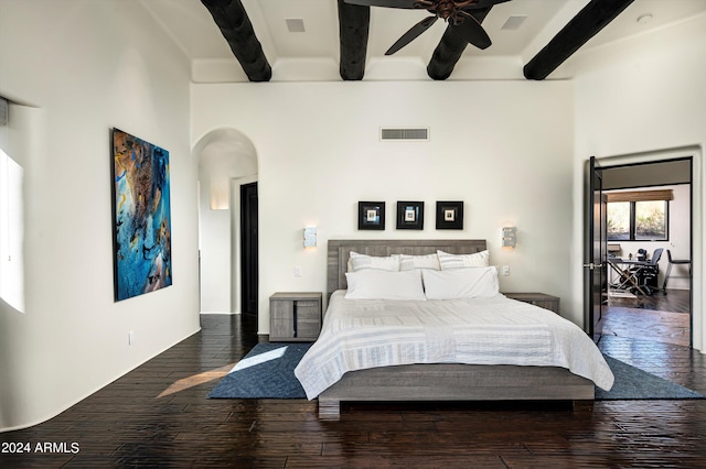 bedroom with a high ceiling, beam ceiling, dark hardwood / wood-style floors, and ceiling fan