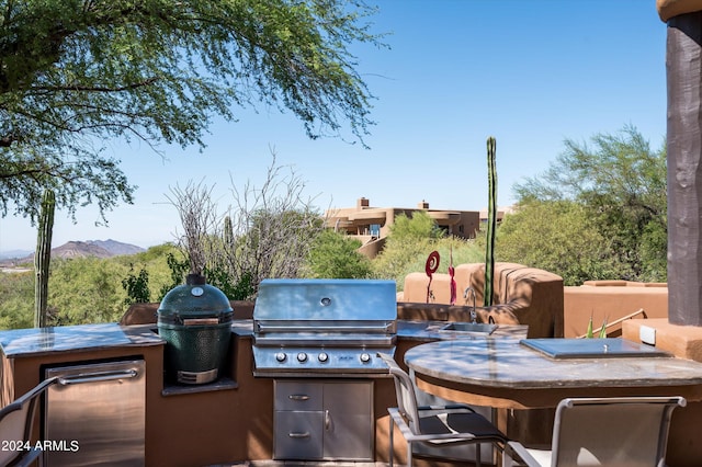 view of patio / terrace with exterior kitchen, a mountain view, and a grill