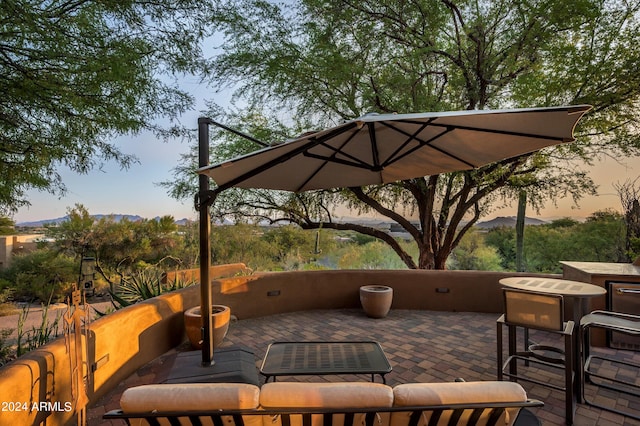 patio terrace at dusk featuring a mountain view