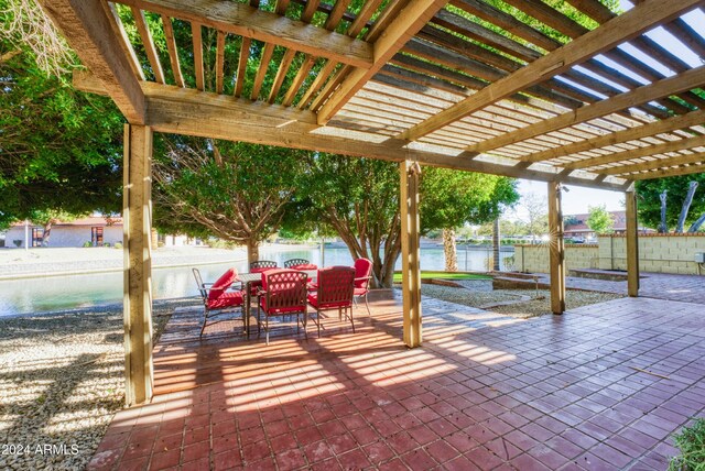 view of patio featuring a pergola and a water view