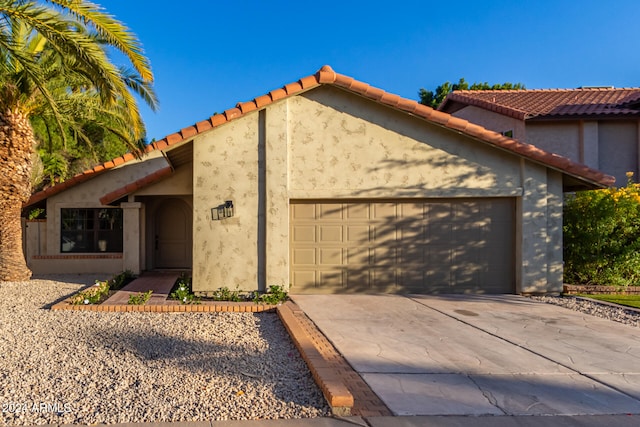 mediterranean / spanish home featuring a garage