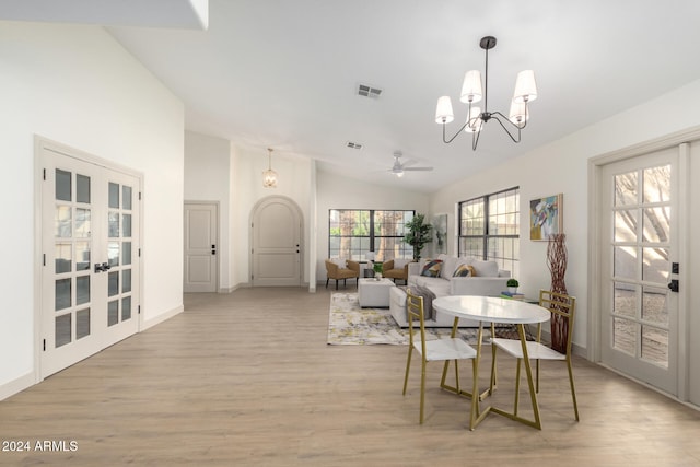 dining space with light wood-type flooring, a wealth of natural light, and lofted ceiling