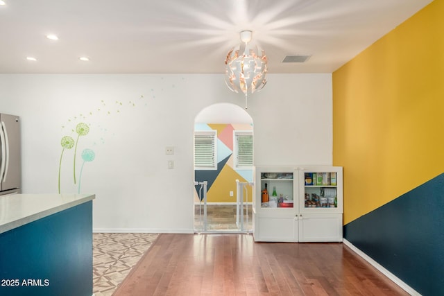 dining room featuring wood-type flooring and an inviting chandelier