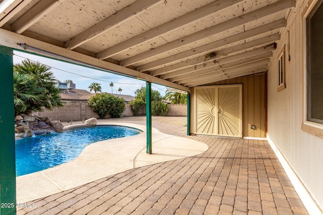 view of swimming pool with pool water feature and a patio area