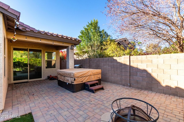 view of patio / terrace featuring a fire pit, grilling area, and a hot tub