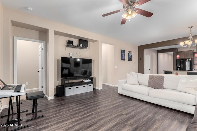 living room featuring dark wood-type flooring and ceiling fan with notable chandelier