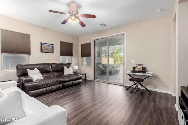 living room with dark wood-type flooring and ceiling fan