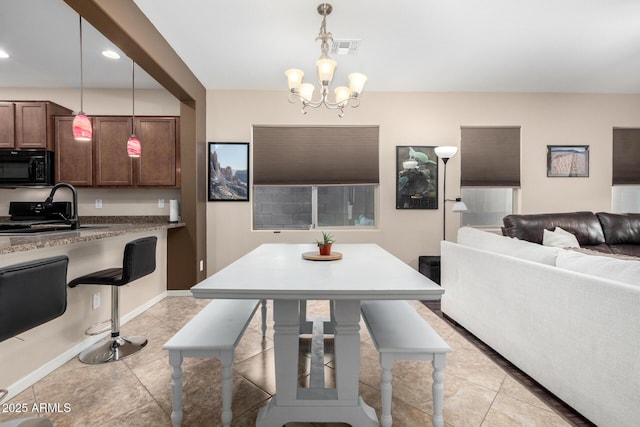 dining room with sink, a chandelier, and light tile patterned floors