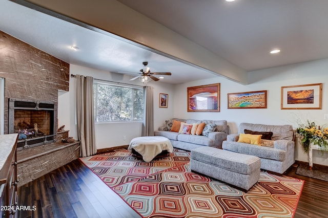 living room featuring hardwood / wood-style flooring, ceiling fan, a stone fireplace, and beamed ceiling