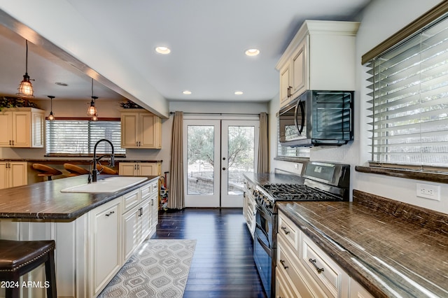 kitchen featuring pendant lighting, french doors, stainless steel range with gas cooktop, sink, and dark hardwood / wood-style floors