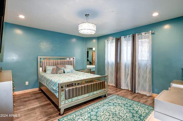 bedroom with wood-type flooring and a chandelier