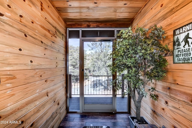 doorway with wooden walls, dark wood-type flooring, and wooden ceiling