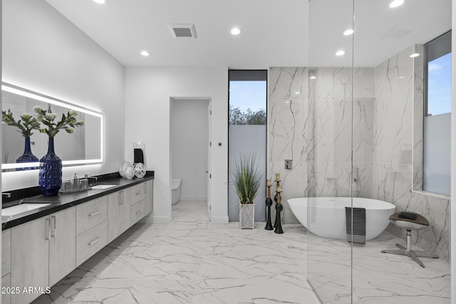 bathroom featuring visible vents, marble finish floor, a sink, recessed lighting, and a soaking tub