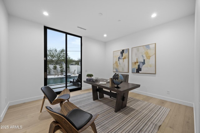 office featuring recessed lighting, floor to ceiling windows, light wood-type flooring, and baseboards