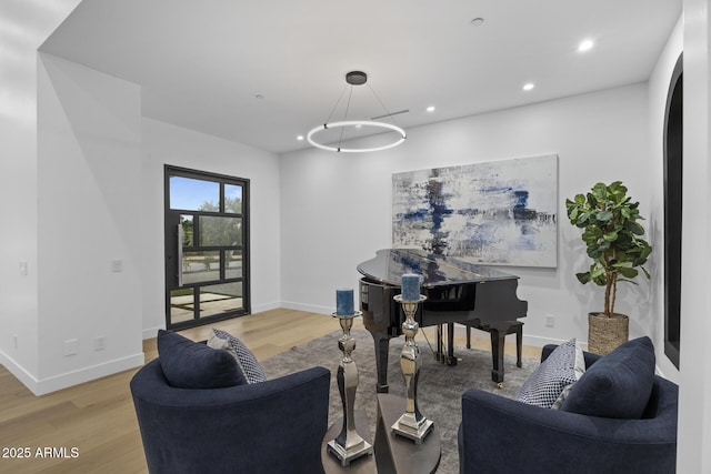 living area with recessed lighting, baseboards, and wood finished floors