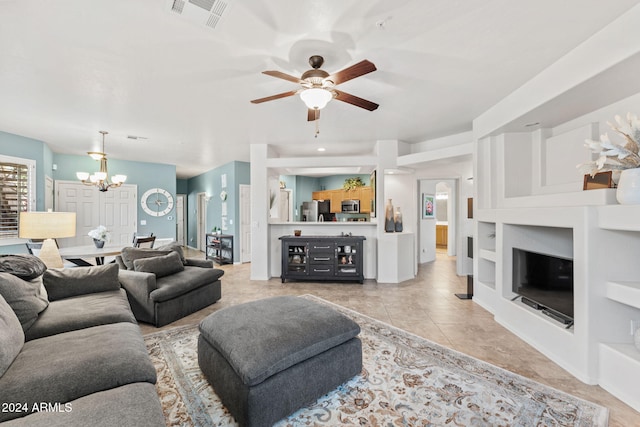 living room featuring light tile patterned flooring and ceiling fan with notable chandelier