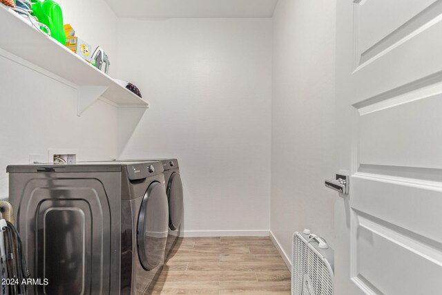 laundry room with light hardwood / wood-style floors and independent washer and dryer