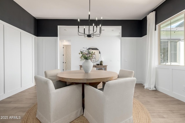 1248 E Jude Ln, Gilbert, AZ 85298 - dining space featuring a chandelier, a decorative wall, light wood finished floors, and wainscoting