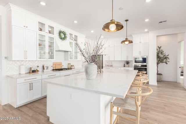 1248 E Jude Ln, Gilbert, AZ 85298 - kitchen featuring stainless steel oven, built in microwave, tasteful backsplash, a kitchen bar, and an island with sink
