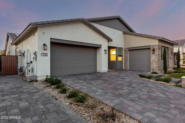 1248 E Jude Ln, Gilbert, AZ 85298 - view of front facade featuring a garage, stucco siding, decorative driveway, and a gate