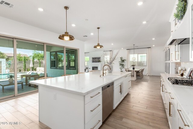 1248 E Jude Ln, Gilbert, AZ 85298 - kitchen featuring a sink, appliances with stainless steel finishes, under cabinet range hood, white cabinets, and a center island with sink