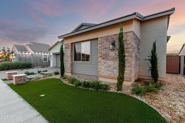 1248 E Jude Ln, Gilbert, AZ 85298 - property exterior at dusk with stone siding, stucco siding, and a garage