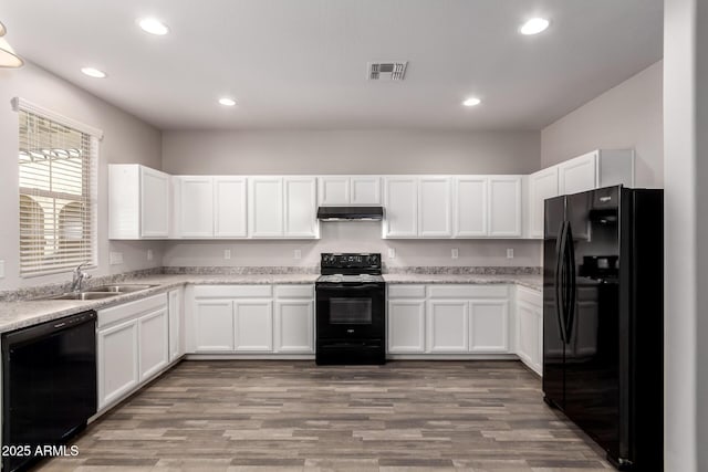 kitchen with sink, white cabinetry, light stone counters, light hardwood / wood-style flooring, and black appliances