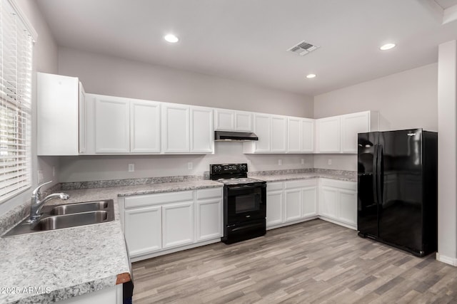 kitchen with sink, light hardwood / wood-style flooring, black appliances, and white cabinets