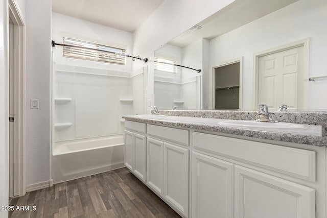 bathroom with washtub / shower combination, vanity, and hardwood / wood-style floors