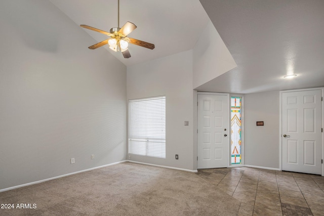 carpeted foyer with high vaulted ceiling and ceiling fan