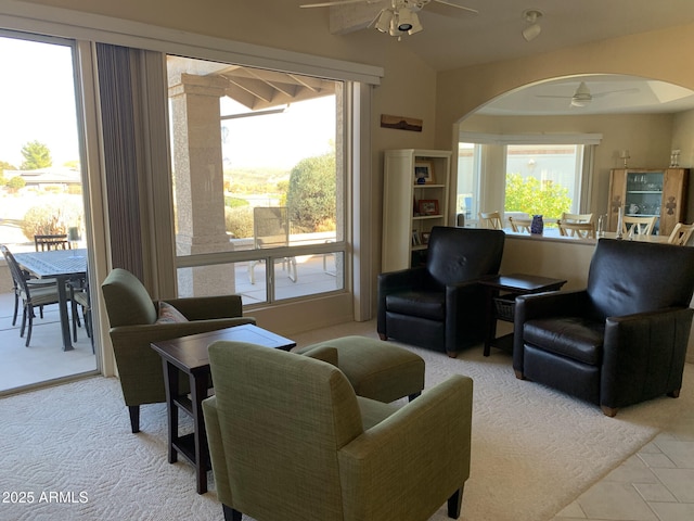 living room with ceiling fan, vaulted ceiling, and a wealth of natural light