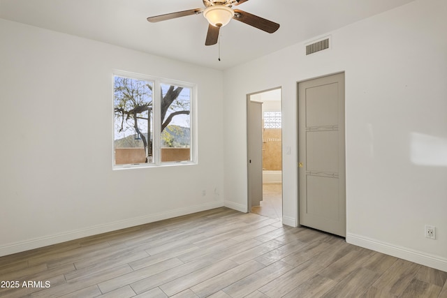 empty room with light wood-type flooring, baseboards, visible vents, and a ceiling fan