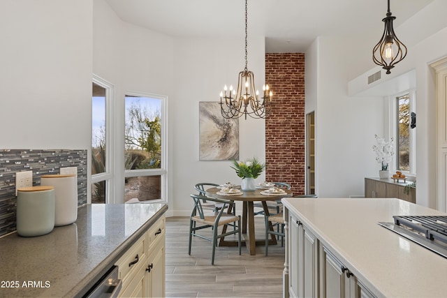 kitchen featuring light wood finished floors, a chandelier, a wealth of natural light, and decorative light fixtures