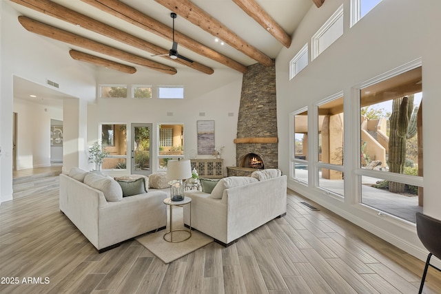 living area featuring a healthy amount of sunlight, visible vents, and wood finished floors