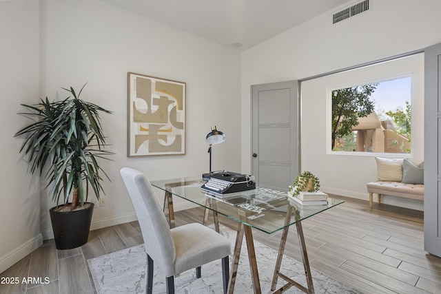 office space featuring baseboards, visible vents, and wood finished floors