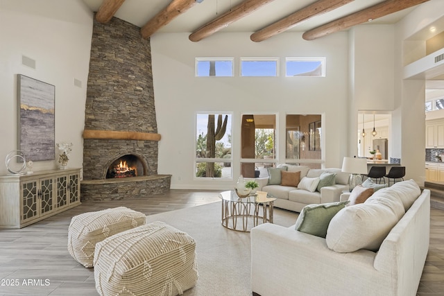 living area featuring a healthy amount of sunlight, a fireplace, visible vents, and wood finished floors