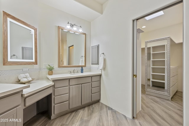 full bathroom with wood finished floors, vanity, and decorative backsplash