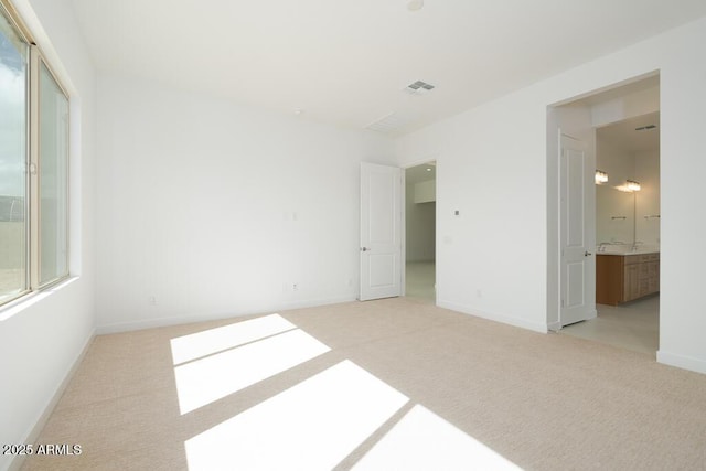 unfurnished bedroom with carpet flooring, visible vents, baseboards, and connected bathroom