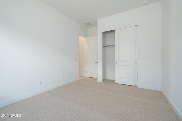 unfurnished bedroom with a closet, visible vents, baseboards, and carpet