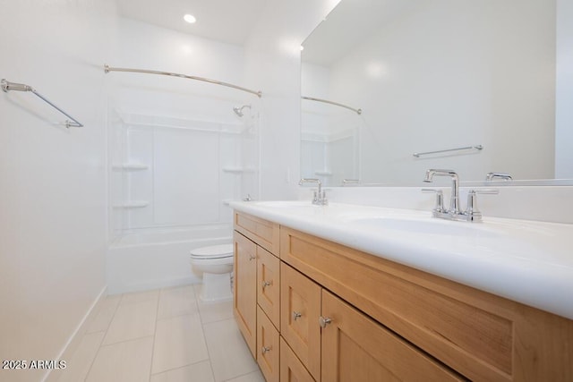 bathroom featuring tile patterned flooring, double vanity, toilet, and a sink