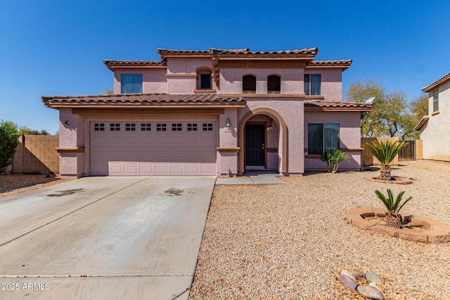 mediterranean / spanish house with driveway, stucco siding, fence, and a tile roof