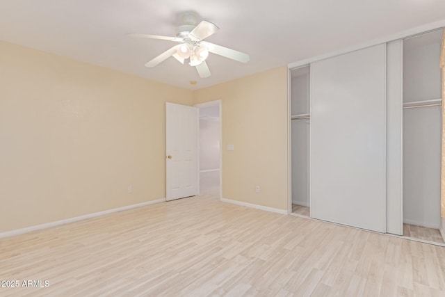 unfurnished bedroom with light wood-type flooring, a closet, ceiling fan, and baseboards