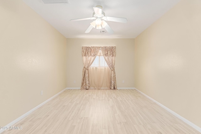 spare room with light wood-style flooring, baseboards, visible vents, and ceiling fan