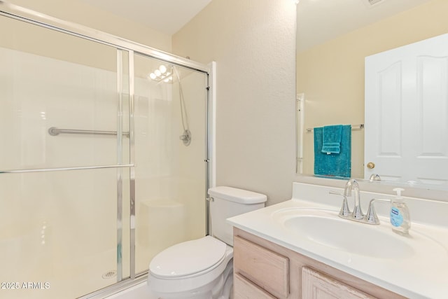 bathroom with toilet, a stall shower, and vanity