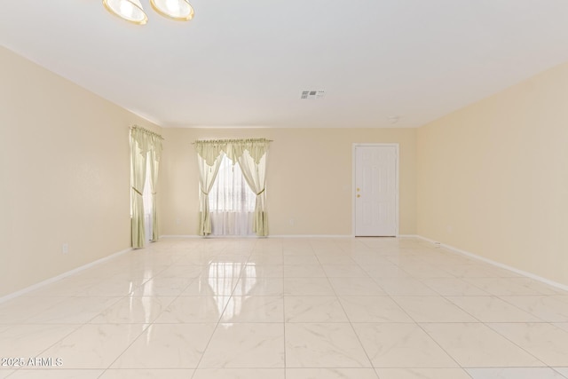 spare room featuring visible vents and baseboards