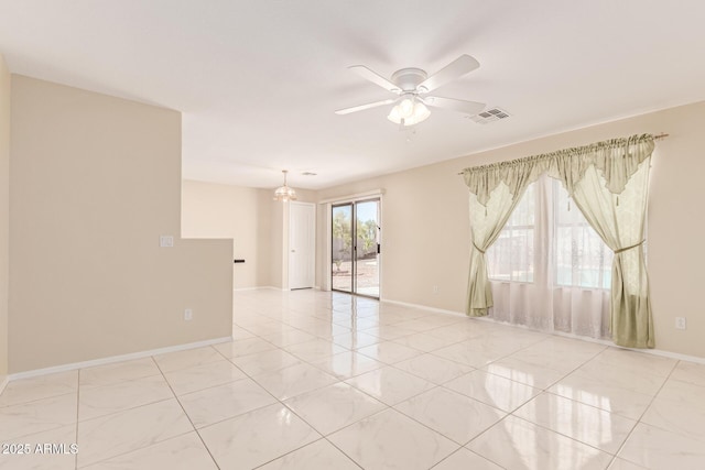 spare room featuring visible vents, baseboards, and ceiling fan