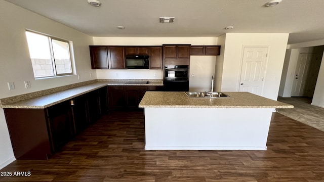 19841 W Cherry Lynn Rd W, Buckeye, AZ 85396 - kitchen with black appliances, dark brown cabinets, a center island with sink, and dark wood-style floors