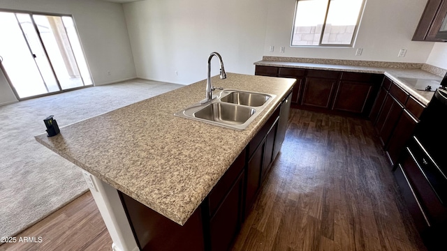 19841 W Cherry Lynn Rd W, Buckeye, AZ 85396 - kitchen with dark brown cabinets, a center island with sink, light countertops, and dark wood-type flooring